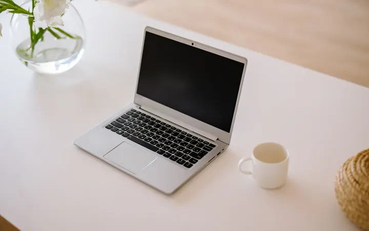 Aufgeklappter Laptop auf einem hellen Schreibtisch